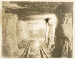Underground Construction with Transportation Track and Seated Worker